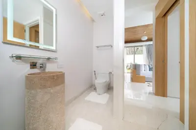 a bathroom with a toilet and a mirror at Brand New & Modern Luxury 4BR Pool Villa in Residence Lux Pride 2 V12 in Bang Tao Beach