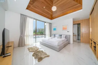 a large bedroom with a bed and a television at Brand New & Modern Luxury 4BR Pool Villa in Residence Lux Pride 2 V12 in Bang Tao Beach