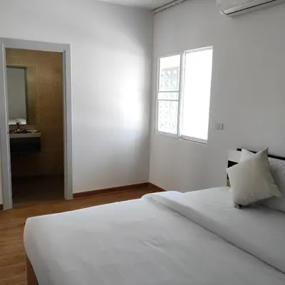 a white bedroom with a bed and a window at The first house 11126 in Ban Phlu Yai