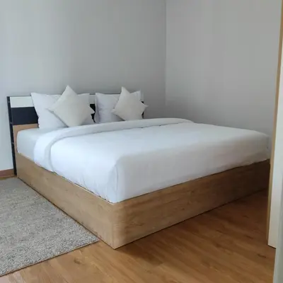a bed with white sheets and pillows on it at The first house 11126 in Ban Phlu Yai