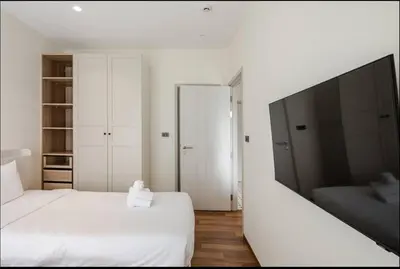 a bedroom with two beds and a flat screen tv at The Title Halo1 2Bedroom Apartment Naiyang beach in Nai Yang Beach