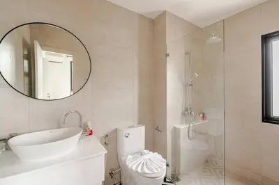 a bathroom with a shower and a toilet and a mirror at The Title Halo1 2Bedroom Apartment Naiyang beach in Nai Yang Beach