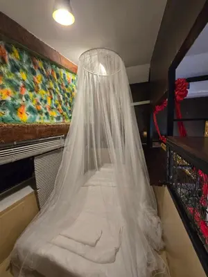 a bed with a mosquito net in a room at Little Home in Town in Ban Lo Long