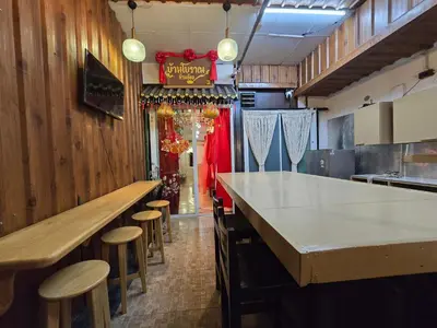 a kitchen with a bar and stools in a restaurant at Little Home in Town in Ban Lo Long