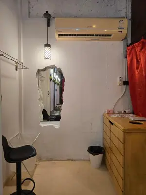 a bathroom with a mirror on the wall and a chair at Little Home in Town in Ban Lo Long
