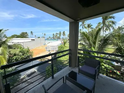 a balcony with a chair and a view of the beach at Private apartment at Kris Condo by Lofty in Surin Beach
