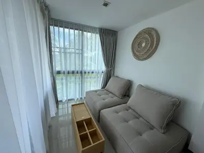 a living room with a couch and a window at Private apartment at Kris Condo by Lofty in Surin Beach