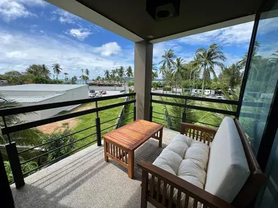 a balcony with a couch and a table and a view at Private apartment at Kris Condo by Lofty in Surin Beach