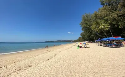 a beach with people and umbrellas and the ocean at Private apartment at Kris Condo by Lofty in Surin Beach