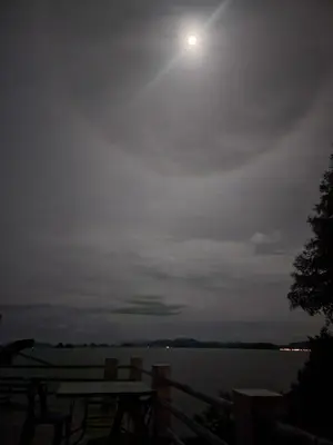 a full moon over a body of water with a table at Esmeralda View Resort - SHA Extra Plus in Ko Yao Yai