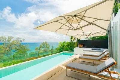 a villa with a swimming pool and an umbrella at Surin Heights Villa in Surin Beach