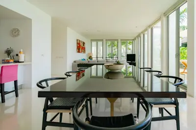 a dining room with a glass table and chairs at Surin Heights Villa in Surin Beach