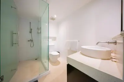 a bathroom with a sink and a shower and a toilet at Surin Heights Villa in Surin Beach