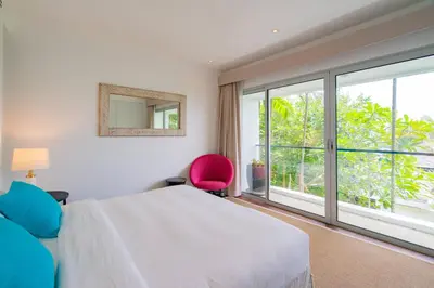a bedroom with a bed and a large window at Surin Heights Villa in Surin Beach