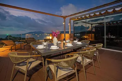 a dining table and chairs on a deck at night at Sapphire Bay Luxury Condominiums Patong, 811 in Patong Beach
