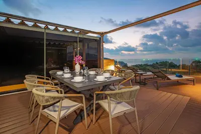 a table and chairs on a deck with a view at Sapphire Bay Luxury Condominiums Patong, 811 in Patong Beach