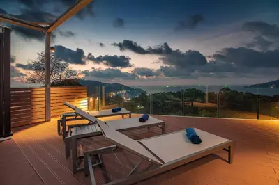 a deck with a table and chairs on a balcony at Sapphire Bay Luxury Condominiums Patong, 811 in Patong Beach