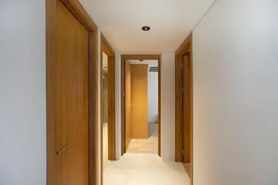 a hallway with wooden doors and a white wall at Sapphire Bay Luxury Condominiums Patong, 811 in Patong Beach