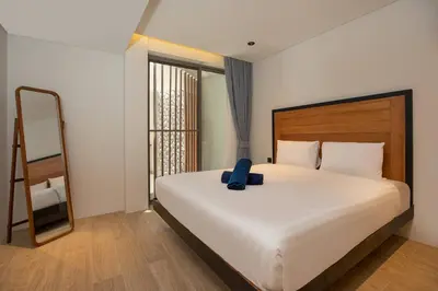 a bedroom with a large white bed with a mirror at Sapphire Bay Luxury Condominiums Patong, 811 in Patong Beach