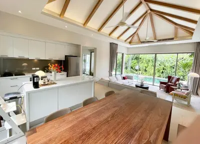 a large kitchen and living room with a wooden table at V164 Famous 5 Trichada Resort 4-Bedroom in Thalang