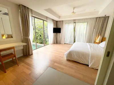 a bedroom with a bed and a desk and window at V164 Famous 5 Trichada Resort 4-Bedroom in Thalang