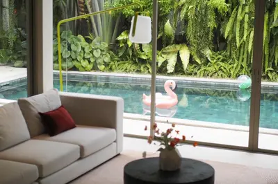 a living room with a white couch and a pink swan in a pool at V164 Famous 5 Trichada Resort 4-Bedroom in Thalang