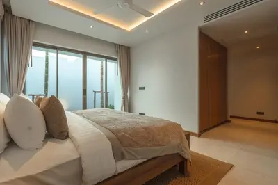 a bedroom with a bed and a large window at V165 Famous Anchan Flora 4 BR in Thalang