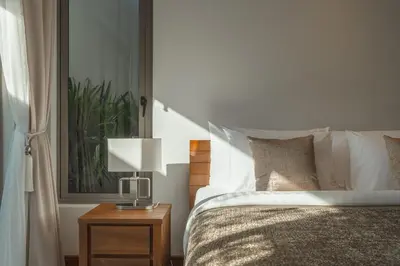 a bedroom with a bed and a table with a lamp at V165 Famous Anchan Flora 4 BR in Thalang