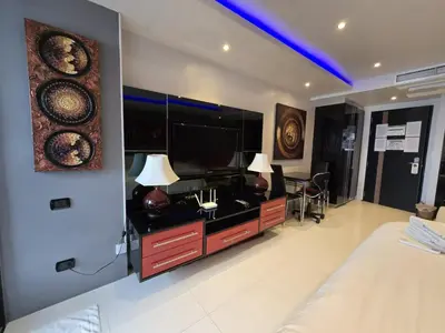 a bedroom with a bed and a flat screen tv at Absolute Bangla Jacuzzi Suites Condo in Patong Beach