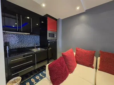 a living room with a couch with red pillows at Absolute Bangla Jacuzzi Suites Condo in Patong Beach