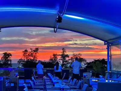 a group of people standing in front of a sunset at Absolute Bangla Jacuzzi Suites Condo in Patong Beach