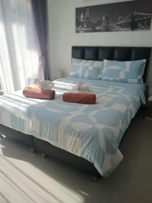 a bedroom with a large bed with two pillows on it at Maikhao Beach Condominium in Mai Khao Beach