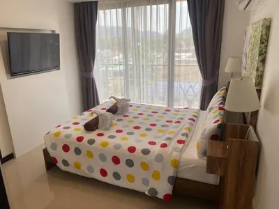 a bedroom with a bed with polka dot sheets and a window at Maikhao Beach Condominium in Mai Khao Beach