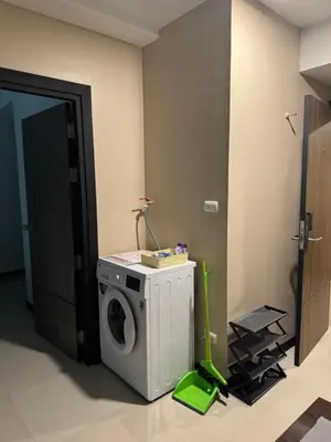 a washing machine in a room with a green mop at Maikhao Beach Condominium in Mai Khao Beach