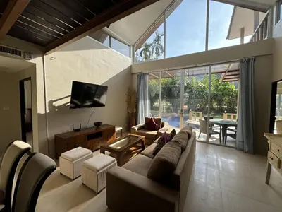 a living room with a couch and a tv at Nai Thon villa with pool, garden, rooftop terrace in Nai Thon Beach