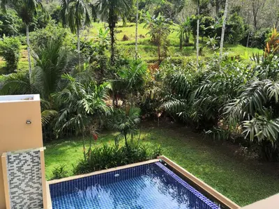 a swimming pool in a garden with palm trees at Nai Thon villa with pool, garden, rooftop terrace in Nai Thon Beach