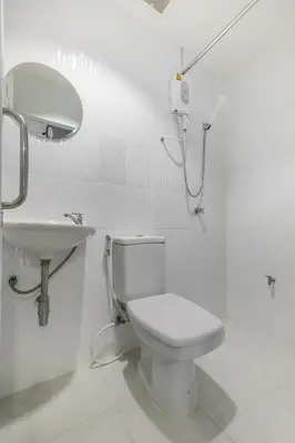 a white bathroom with a toilet and a sink at The Little Nest Phuket in Phuket Town