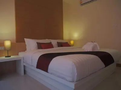 a large white bed in a room with two lamps at The Little Nest Phuket in Phuket Town