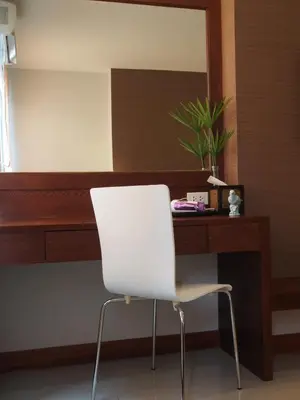 a white chair in front of a desk with a mirror at The Little Nest Phuket in Phuket Town