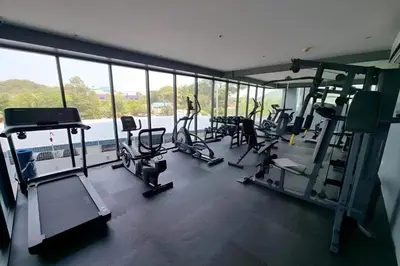 a gym with treadmills and machines in a building at Utopia Guesthouse in Phuket Town