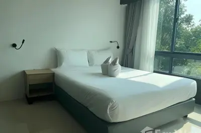 a bed in a room with a large window at Utopia Guesthouse in Phuket Town