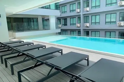 a swimming pool with chaise lounge chairs and a building at Utopia Guesthouse in Phuket Town
