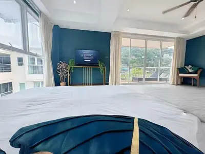 a large bedroom with a large bed and a tv at Peaceful Patong Penthouse in Patong Beach