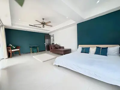 a bedroom with a large bed and a blue wall at Peaceful Patong Penthouse in Patong Beach
