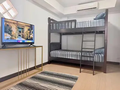 a room with two bunk beds and a flat screen tv at Peaceful Patong Penthouse in Patong Beach
