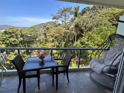 a table and chairs on a balcony with a view at Karon Butterfly Condominium Brandnew, spacious 65m2 full seaview apartment, large pool, 300m from Karon beach in Karon Beach