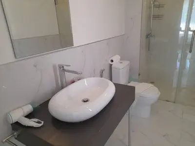 a white bathroom with a sink and a toilet at Karon Butterfly Condominium Brandnew, spacious 65m2 full seaview apartment, large pool, 300m from Karon beach in Karon Beach