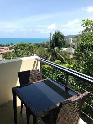 a table and chairs on a balcony with the ocean at Karon Butterfly Condominium Brandnew, spacious 65m2 full seaview apartment, large pool, 300m from Karon beach in Karon Beach