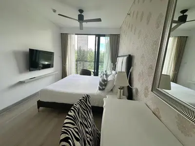 a hotel room with a bed and a mirror and a tv at Lake view apartment in Laguna in Bang Tao Beach