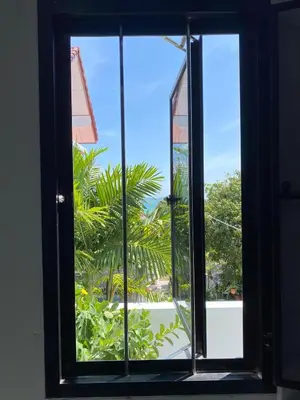 an open window with a view of a palm tree at Detached house Rawai beach in Ban Saiyuan (1)